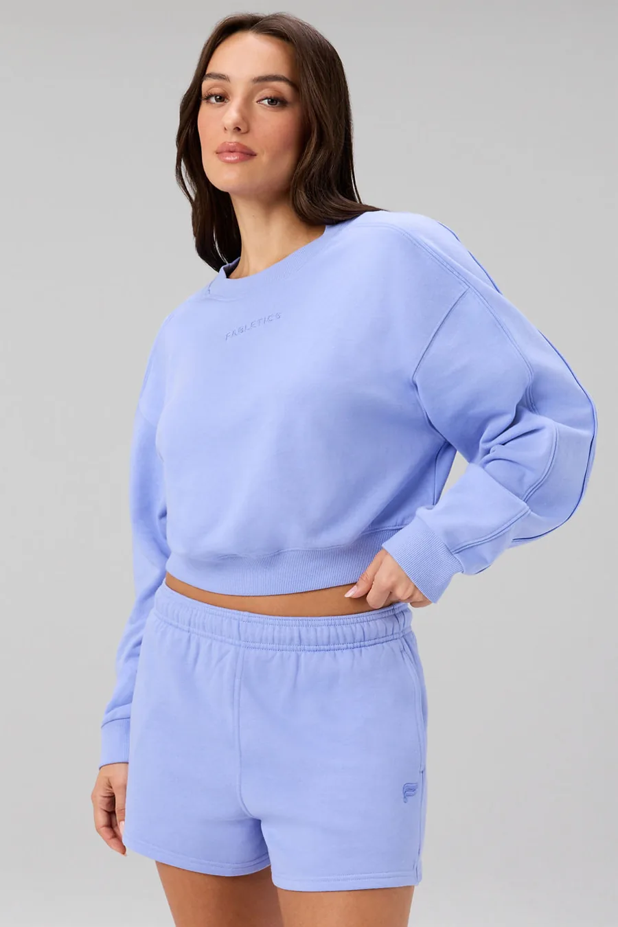 Frau in fliederfarbenem Sweatshirt und dazu passenden Shorts