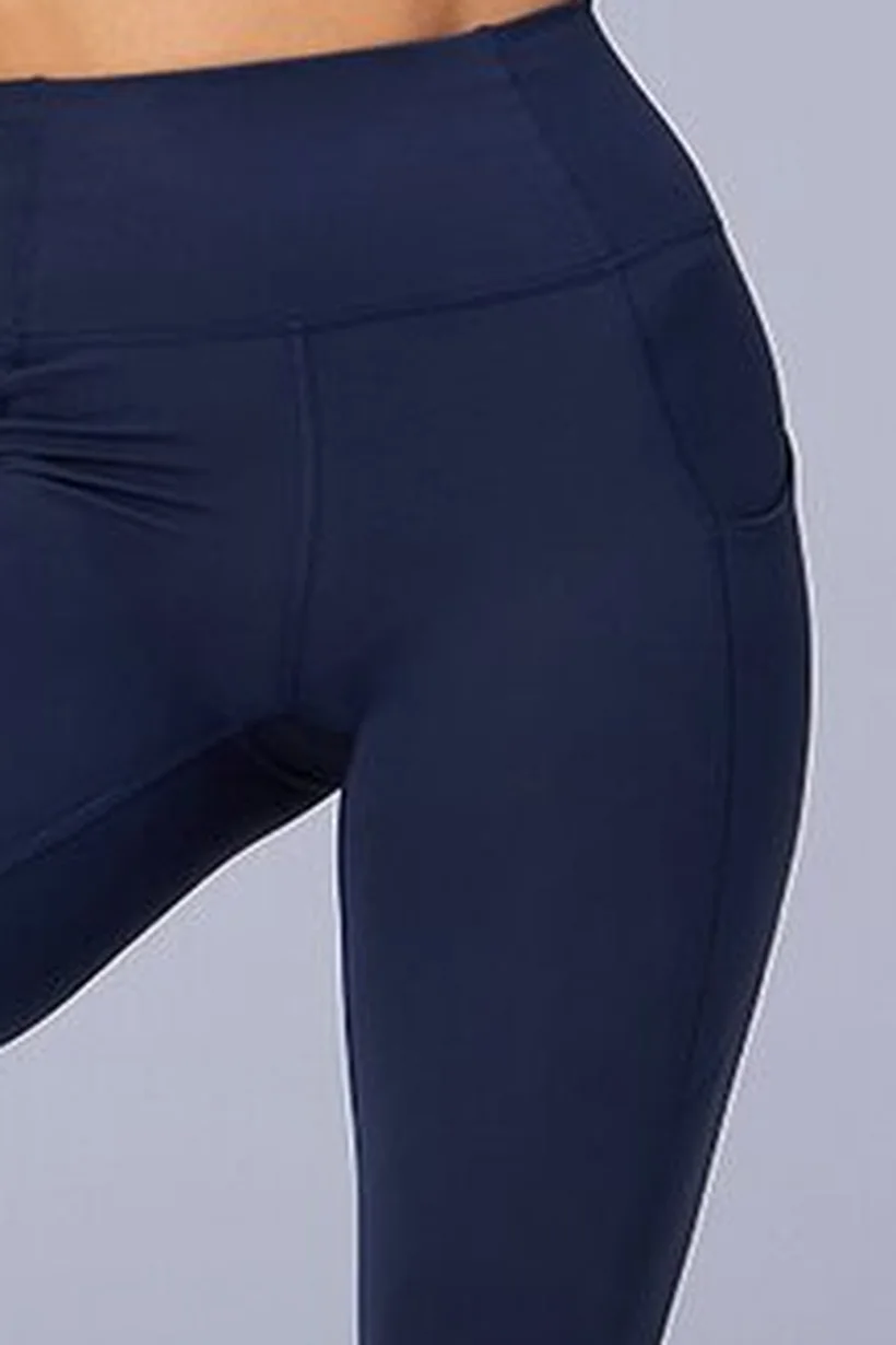 Nahaufnahme einer marineblauen Leggings: breiter Bund und die flache Seitentasche am Oberschenkel